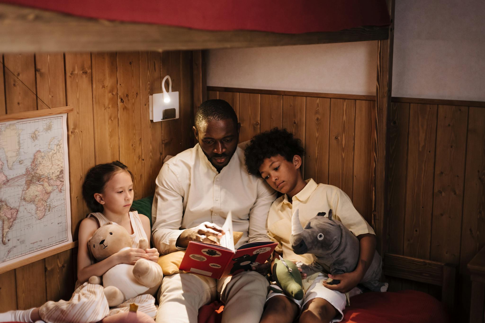 Father reading bedtime story to children, creating a warm family moment indoors.